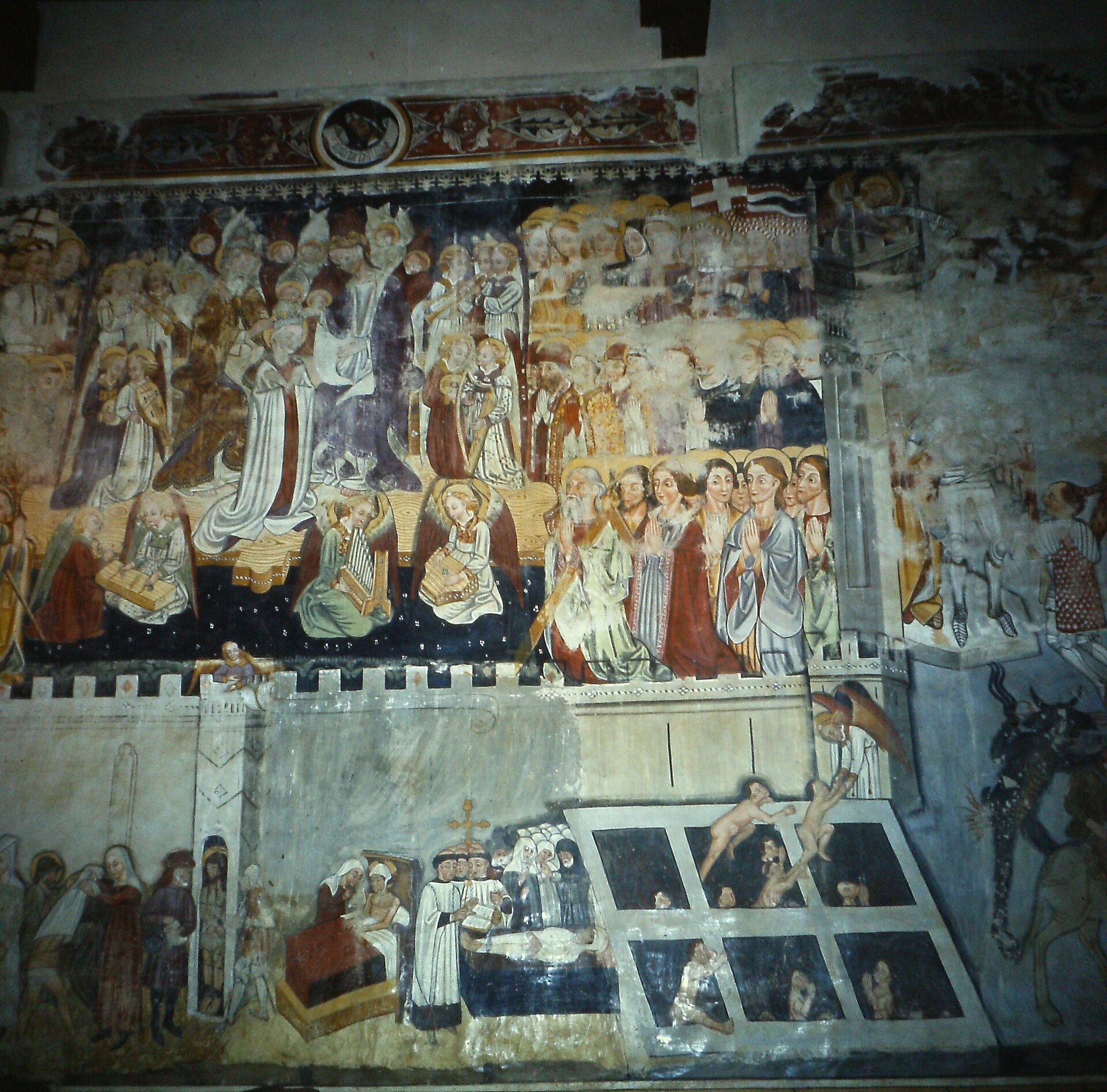 A cycle of historic frescoes showing detachment and paint loss, before the restoration intervention