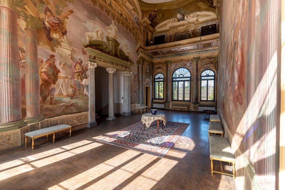 The villa's frescoed hall, with painted walls and wall decorations